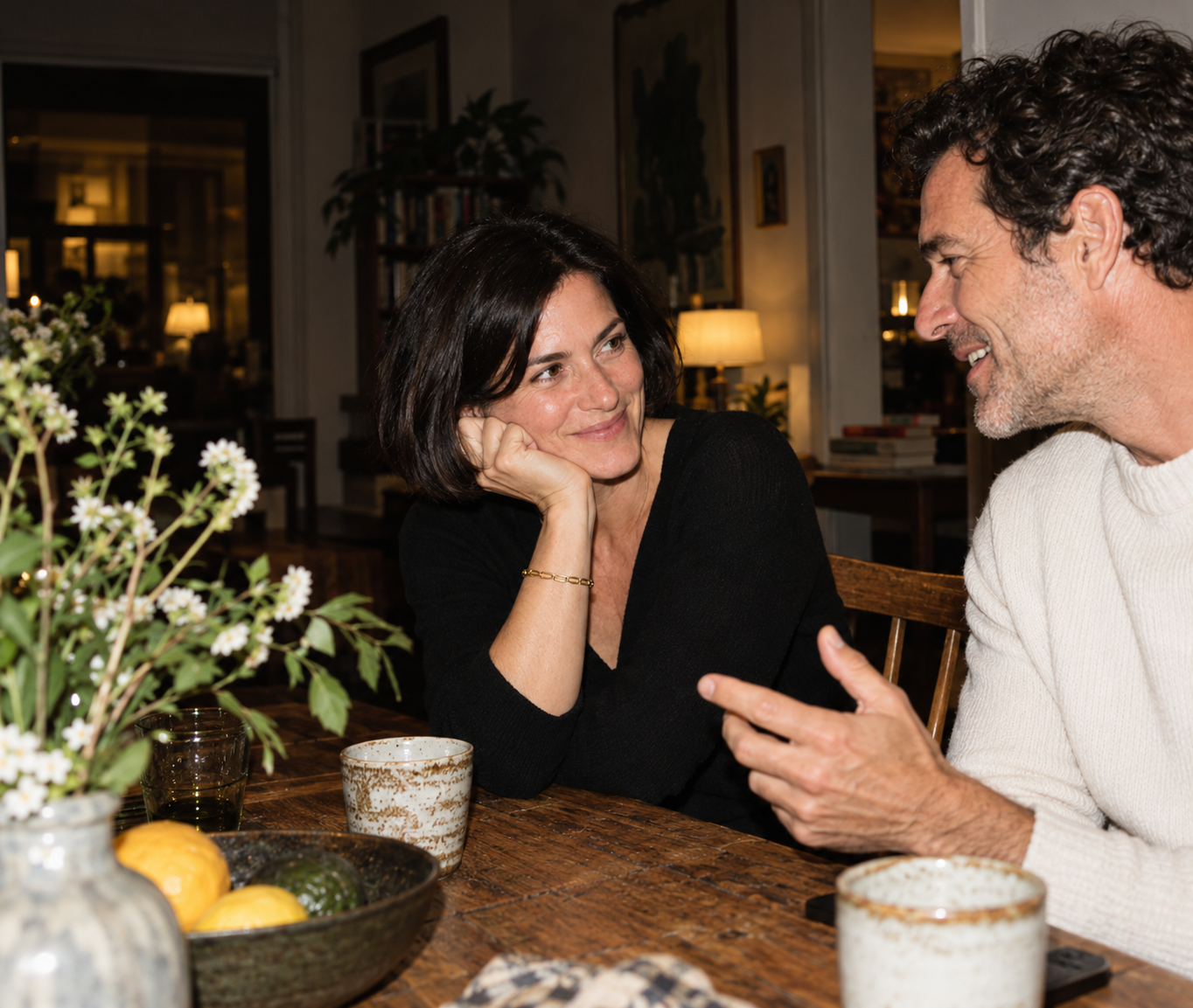 Two people sharing a conversation at a dining table
